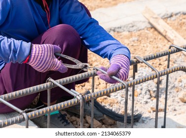 Worker Are Using Pliers To Wire Bundle To Tie The Rebar For Building Foundations In Construction Site.