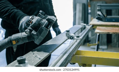 A worker is using a power tool to cut a piece of stone, likely for a construction project