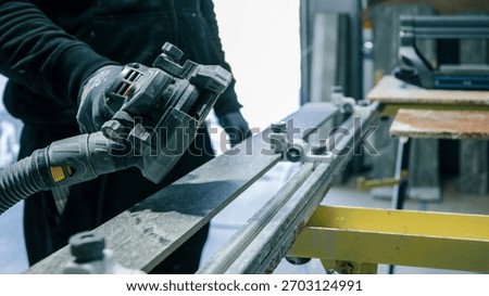 A worker is using a power tool to cut a piece of stone, likely for a construction project