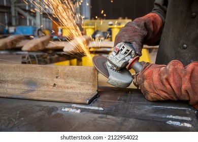 worker using power tools grinding a corner in a factory