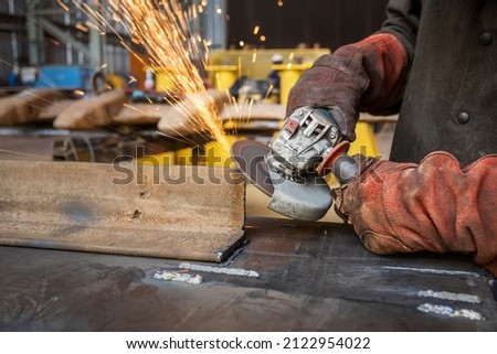 worker using power tools grinding a corner in a factory