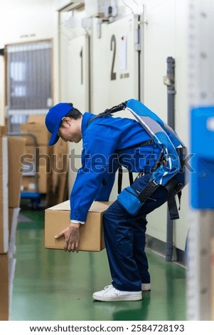 Worker using power-assisted suit in warehouse