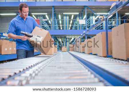 Worker Using Scanner In Warehouse Despatch Area