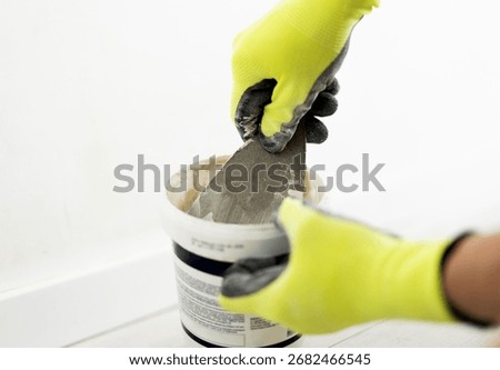Worker Using A Spatula To Apply Wall Putty And Spackle Walls For A Smooth Finish