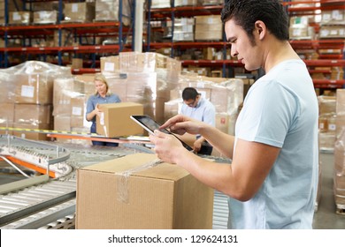 Worker Using Tablet Computer In Distribution Warehouse