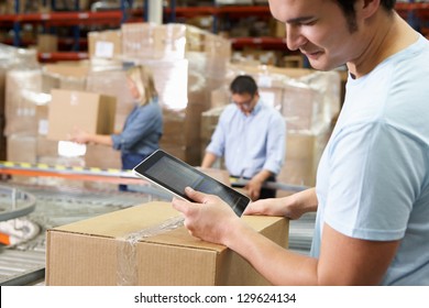 Worker Using Tablet Computer In Distribution Warehouse