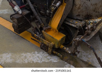 Worker Using Thermoplastic Road Marking Machine To Painting Yellow Lines On Concrete Road Surface.