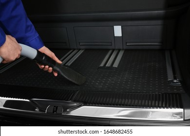 Worker Using Vacuum Cleaner In Automobile Trunk At Car Wash, Closeup