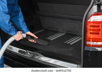 Worker Using Vacuum Cleaner In Automobile Trunk At Car Wash, Closeup