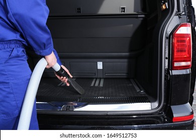 Worker Using Vacuum Cleaner In Automobile Trunk At Car Wash, Closeup