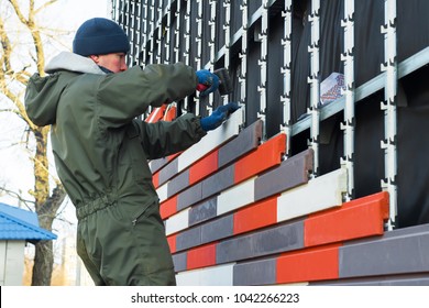 Worker wall cladding stonethe worker makes facing and warming of an external wall of building an artificial decorative stone