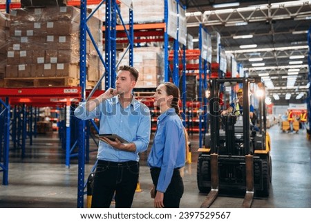 Worker in the warehouse checking the stock is on the shelves at the manufacturing. Engineer is working in the warehouse.