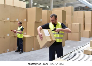 Worker In A Warehouse In The Logistics Sector Processing Packages On The Assembly Line  - Transport And Processing Of Orders In Trade 