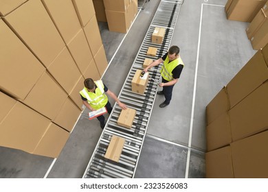 Worker in a warehouse in the logistics sector processing packages on the assembly line  - transport and processing of orders in trade  - Powered by Shutterstock