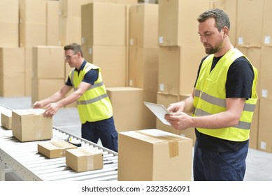 Worker in a warehouse in the logistics sector processing packages on the assembly line  - transport and processing of orders in trade  - Powered by Shutterstock