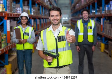 Worker In Warehouse With Thumb Up Wearing Yellow Safety Vest