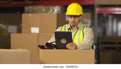 Worker In Warehouse Using Digital Tablet