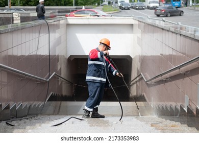worker washes tiles on the walls in an underpass in Moscow, Russia