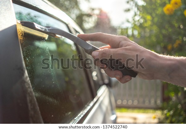 worker washing the
car window with a
scraper