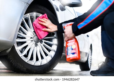 Worker Washing Car's Alloy Or Alluminium Wheels Using Cleaning Spray On A Car Wash. Rims Detailing 