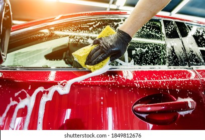 Worker Washing Red Car With Sponge On A Car Wash