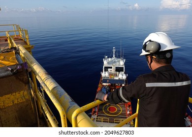 Worker Watch Cargo Being Loaded From Oil And Gas Platform Onto A Supply Vessel