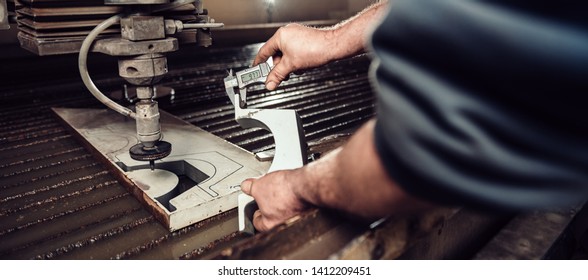 Worker At Water Jet Cutter Checking Cut Section Measures With Digital Caliper