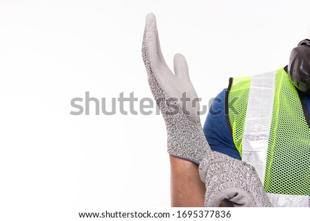 Worker wearing construction safety gloves before working. Caucasian contractor or engineer guy preparing for work at worksite by wear safety glove for protect labor hands copy space, isolated on white