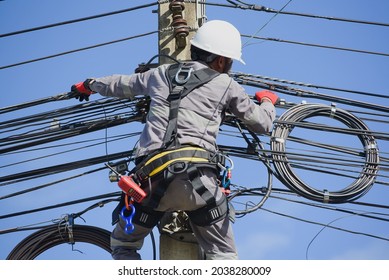 Worker Wearing Equipment Safety Harness Full Body, Electrician Climbing Poles, Repairing Power Line  