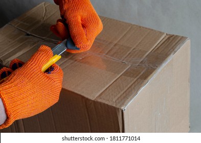 A Worker Wearing Protective Gloves Changes The Dull Blade Of A Knife. Hands With A Special Device Remove The Blunt Part Of The Knife. Selective Focus.