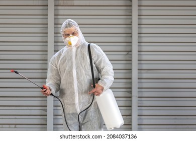 Worker Wearing Protective Suit Disinfection Gear Disinfect Surface Public Place Parking. Side View Of Disinfector Safety Overall And Respiratory Mask Covid Pandemic Disinfection Preventive Measures