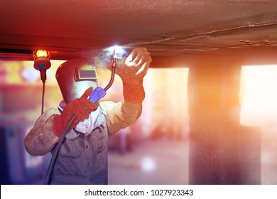worker welding aboard with ballast tank of cargo ship at floating dry dock in shipyard 