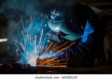 Worker Is Welding Assembly Part In Car Factory