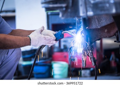 Worker Welding A Car