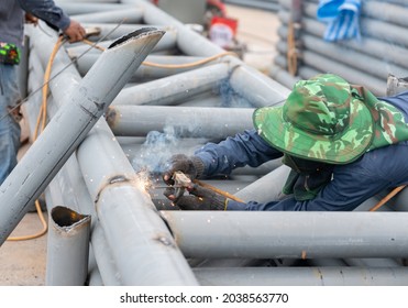 Worker Welding A Grey Rust Proof Large Iron Pole On The Construction Site.