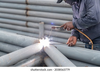 Worker Welding Pole Structure Outdoor With Spark In Car Park.paint Grey Rust Proof.