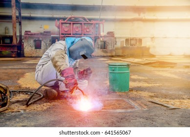 worker welding protective clothing, ship repair with tank bottom plate storage tank in shipyard