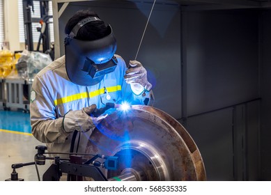 Worker is welding the pump's impeller for repair