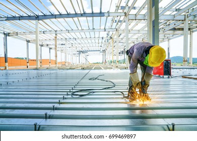 Worker is welding rebar shear key for steel metal deck slab of mezzanine floor in construction buiding