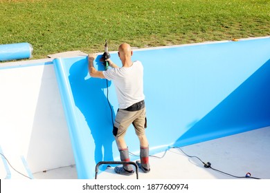 A worker welds plastic cover for water pool. Water pool cover replacement. Plastic Welding Machine. Swimming pool care concept. - Shutterstock ID 1877600974