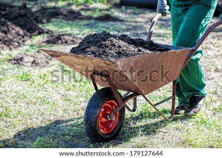 Worker with a wheelbarrow full of compost