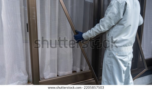A worker who\
installs a screen window.