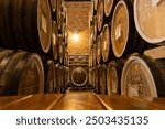 Worker in wine , whiskey or brandy warehouse sorting and rotating barrel . Two winemakers in vintage , traditional wine factory rolls barrel . Shot on ARRI ALEXA Cinema Camera in Slow Motion .