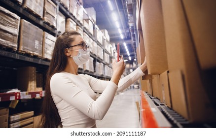 Worker Woman Warehouse Worker In Protective Mask With Phone Scan Cardboard Box, Service Delivery.