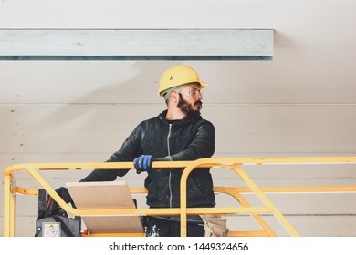 Worker at work in the construction of a plasterboard wall.
