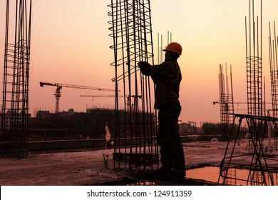 worker working with concrete iron near sunset