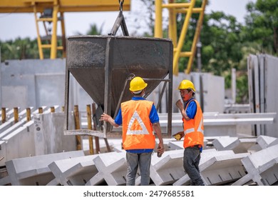 Worker are working at a construction site worker is handling a tool, possibly a trowel, while the other is operating or guiding a concrete hopper is construction building business concept. - Powered by Shutterstock