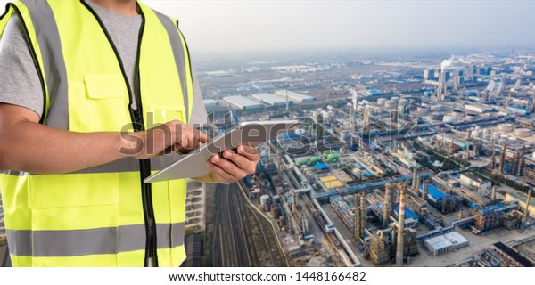 worker working on pad with oil and gas\
refinery background