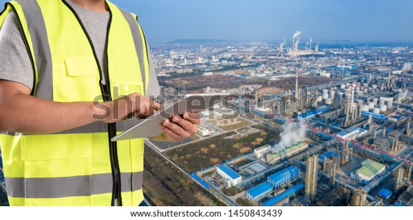 worker working on pad with oil and gas\
refinery background