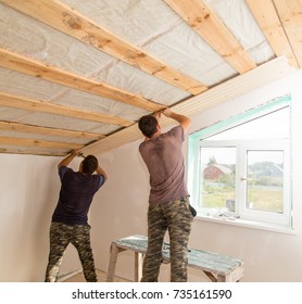 worker working on a wooden ceiling in the house - Shutterstock ID 735161590